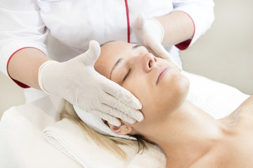 Fototapeta na wymiar Massage and facial peels at the salon using cosmetics 
