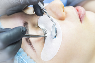 Woman on the procedure for eyelash extensions, eyelashes lamination. 