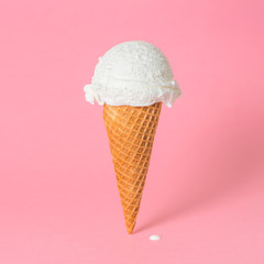summer funny creative concept of wafer cone with melting ice cream on pink background, copy space