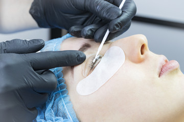 Obraz na płótnie Canvas Woman on the procedure for eyelash extensions, eyelashes lamination. 