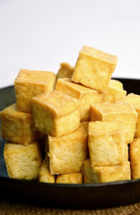 Fried Tofu cut like a dice in wok on white background.