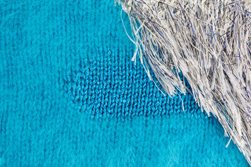 knitted fabric background in turquoise acrylic and angora yarn with white fringed yarn