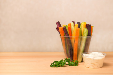 colorful carrots and cucumbers vegetables julienned for salad and sour cream dip decorated parsley over wooden board, concept of healthy lifestyle
