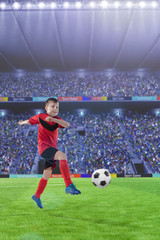 kid football player kicking the ball