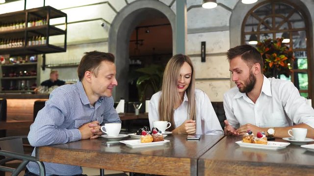 Happy colleagues from work socializing in restaurant and eating together