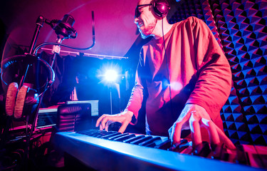 Fototapeta na wymiar Young man playing piano in sound recording studio.