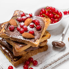 stack of fried toast with chocolate cream, red currant and almon