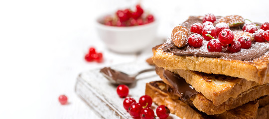 stack of fried toast with chocolate cream, red currant and almonds