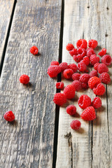 Fototapeta na wymiar Fresh juicy tasty raspberries scattered on table