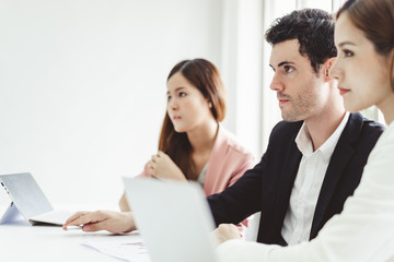 Business people concentrate discussing while meeting in office, working with laptop