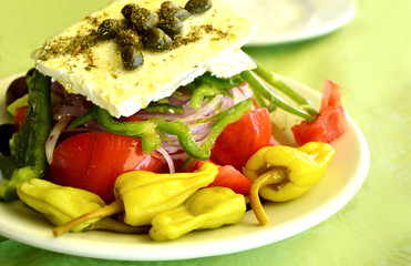 Greek salad on green table cloths.
Healthy and benefits of Greek salad.