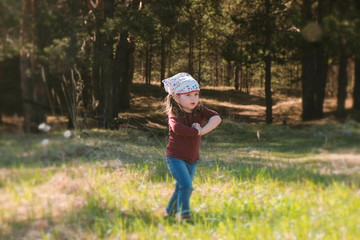 Little cute girl walks through the woods and sings a song.