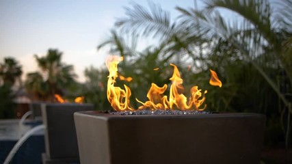 Fire in slow motion with pool, fountain, and trees
