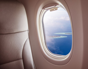 Airplane window with beautiful Maldives island view