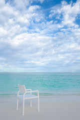 Summer concept , White chair on the beach white sand and turquoise sea color at maldives on the weekend holidays