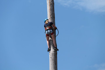 A Female Lumberjack Practicing High Pole Climbing.
