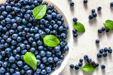 Fresh blueberries on plate, top view on on white background. Forest berries, healthy nutrition concept.