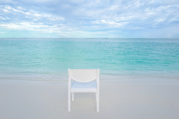 Summer concept , White chair on the beach white sand and turquoise sea color at maldives on the weekend holidays