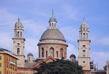 Fototapeta na wymiar Genoa, Italy - view from the harbor of the domes of the Santa Maria Assunta church in Renaissance style