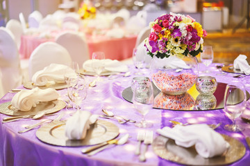Obraz na płótnie Canvas Dinner table setting with a glass vase of flower bouquet decoration