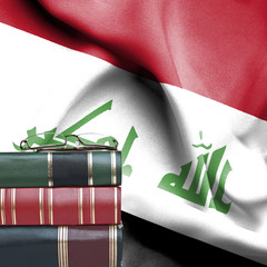 Education concept - Stack of books and reading glasses against National flag of Iraq