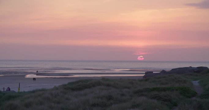 Gold hour sunset in Denmark Scandinavia Europe on beach with people walking