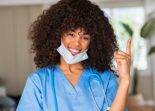 African American Woman Medical Professional Very Happy Pointing With Hand And Finger To The Side