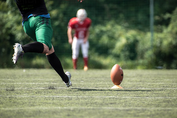 American football player kicking ball