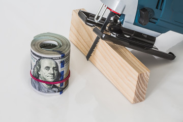 Wooden bar with a roll of money and the electric tool for wood processing