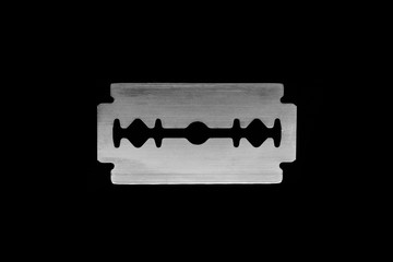 Close up view of metallic razor blade isolated on black background surface