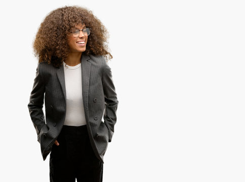 African american business woman wearing glasses looking away to side with smile on face, natural expression. Laughing confident.