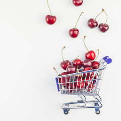 Ripe cherries in a shopping cart isolated