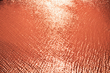 wave of a sandy beach and glare of the sun,  red   background,     texture.