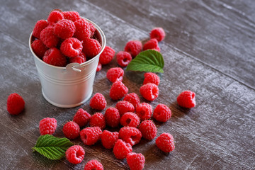 Ripe berry raspberries on the table. Dark wooden background.