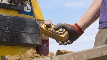 Geotechnical investigation - a hand holding a crane control button - obrazy, fototapety, plakaty