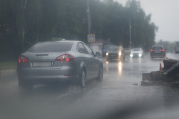 Fototapeta na wymiar Car splashes trough water on a partly flooded road.