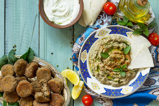 Arabic cuisine. Fresh homemade creamy mung hummus with spicy, falafel, sour cream sauce. Ramadan food. Top view flat lay background, copy space.