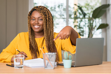 African american woman studying with laptop very happy pointing with hand and finger