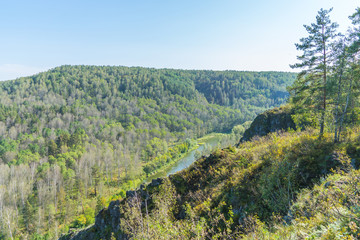 Mountain river in Siberia between the hills and mountains in the early autumn