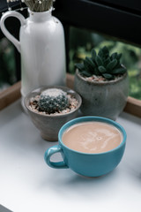 hot coffee cup with cactus on pottery decoration objects.hot coffee mug on white table.