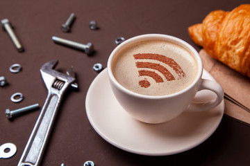 Cup of coffee with WiFi sign on the foam. Free access point to the Internet WiFi. Repair service...