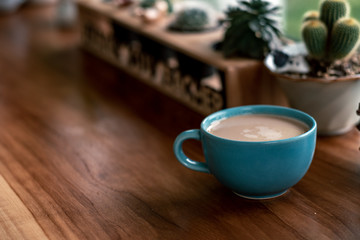 hot coffee cup with cactus on pottery decoration objects.hot coffee mug on white table.