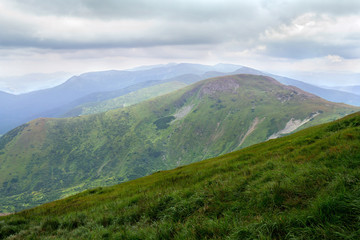 Fototapeta premium Landscape of mountains with hills and glades with cloudy sky. Carpathian mountains