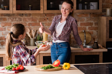 little cook. adolescent girl prepared salad from fresh organic food ingredients. healthy eating and...