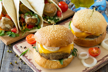 Arabic cuisine. Ramadan food. Delicious fresh homemade vegetarian mung cutlets burger and tortilla with falafel on a wooden kitchen table. Street food, fast food.