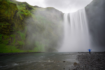 Iceland - Skogafoss waterfall with person arms stretched wide