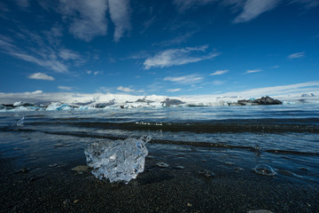 Iceland - Crystal clear peace of ice at black sand beach of glacier lagoon