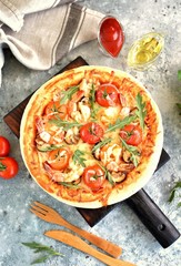 Pizza with big shrimps, cherry tomatoes, portobello mushrooms, mozzarella and arugula