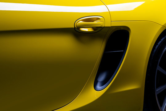 Fototapeta Car detailing series: Closeup of clean yellow sports car’s door