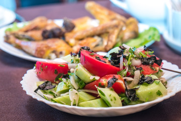 Tomato and cucumber salad with onion, pepper and parsly